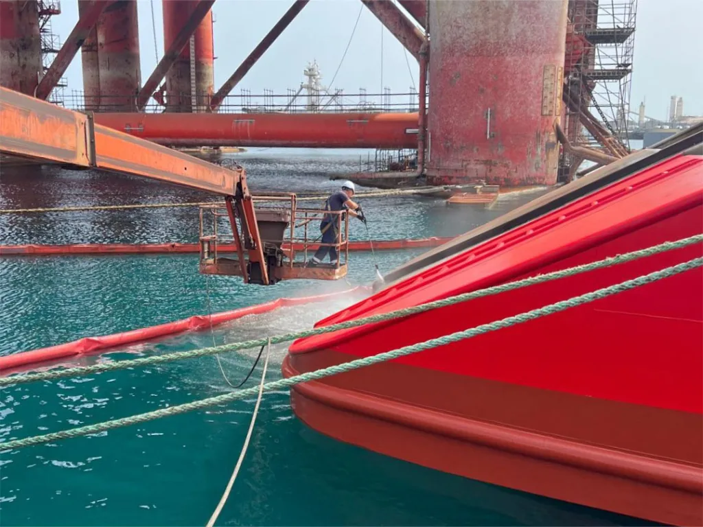 Trabajador de limpiezas navales tiburón limpiando casco de barco a presión